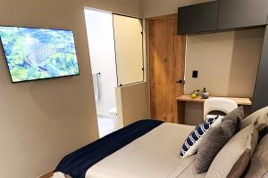 a bedroom with a bed and a flat screen tv at Las Lomas Luxury House2 in Medellín