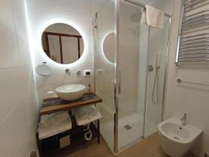 ein weißes Bad mit einem Waschbecken und einer Dusche in der Unterkunft VILLA LUNA in Comeana
