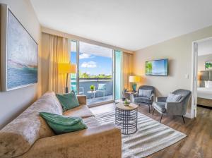 a living room with a couch and chairs and windows at Waterview Condo- Spacious 2 bedroom - Central - Steps to Beach in Fort Lauderdale