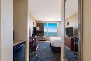 a hotel room with a bed and a large window at Comfort Inn South Oceanfront in Nags Head