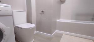 biała łazienka z toaletą i prysznicem w obiekcie ZEUS BEACH Apartament w mieście Torrevieja