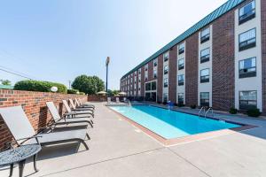 a pool with lounge chairs next to a building at Comfort Inn Aikens Center in Martinsburg