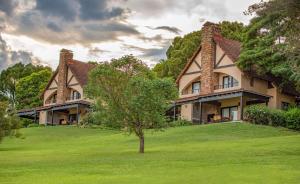a house on a hill with a tree in the yard at Pine Lake Resort in White River