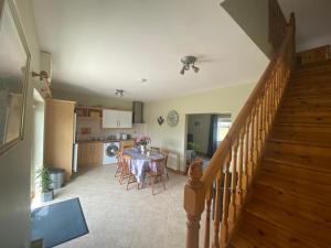 a kitchen and dining room with a table and a staircase at Loch Nuala in Galway