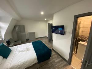 a hotel room with a bed and a flat screen tv at Nice Ensuite Rooms close to Anfield Stadium & city centre in Liverpool