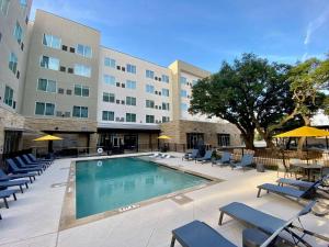 una piscina con sillas y un hotel en Cambria Hotel Austin Uptown near the Domain, en Austin