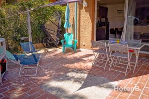 a patio with a table and chairs and an umbrella at Natural Escape Air-Conditioned T2 BIS Pools and Private Estate in Fitou! in Fitou +25 photos