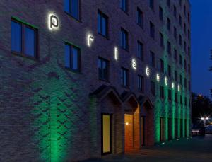 un edificio di mattoni con luci accese di notte di prizeotel Hamburg-City ad Amburgo