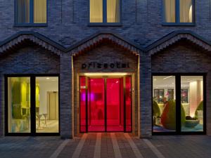 une façade de magasin avec portes et fenêtres rouges dans l'établissement prizeotel Hamburg-City, à Hambourg