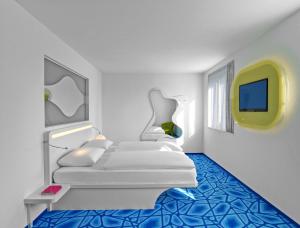 a white room with a bed and a tv at Prize by Radisson, Hamburg City in Hamburg