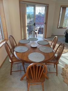 a wooden table with four chairs and a table and a room at Sandy Bay Villa in Sandy Bay