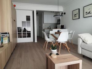 a living room with a table and white chairs at Westeinders Sea View in Middelkerke
