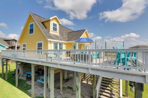 ein gelbes Haus mit einer Terrasse und einem Spielplatz in der Unterkunft Home with Ocean-View Deck and BBQ Steps to the Beach! in Surfside Beach