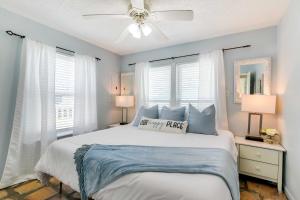 Schlafzimmer mit einem Bett, einem Deckenventilator und Fenstern in der Unterkunft Home with Ocean-View Deck and BBQ Steps to the Beach! in Surfside Beach