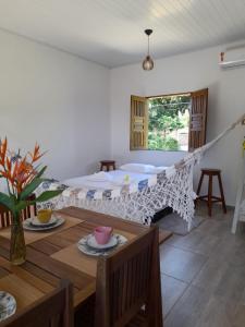 a bedroom with a bed and a wooden table and a table sidx sidx at Vila Marés in São Cristóvão