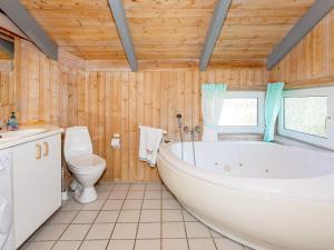 a bathroom with a tub and a toilet at Secluded Haven in Thorup - By Traum Ferienwohnungen in Torup Strand +9 photos