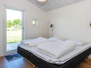 two beds in a room with a large window at Holiday home Rønde IX in Rønde