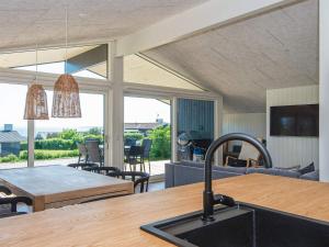 Il comprend une cuisine et un salon avec une table et un évier. dans l'établissement Holiday home Rønde IX, à Rønde