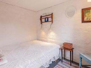 1 dormitorio con cama blanca y mesa en Holiday home Bedsted Thy IV, en Bedsted Thy
