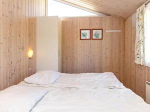 a bedroom with a white bed in a wooden wall at 14 person holiday home in Væggerløse-By Traum in Marielyst +33 photos