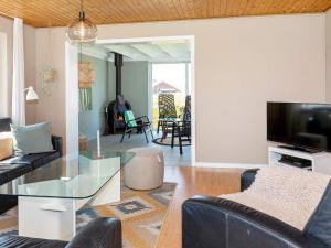 ein Wohnzimmer mit einem Sofa und einem Glastisch in der Unterkunft Holiday Home Sandnæshagevej II in Lild Strand