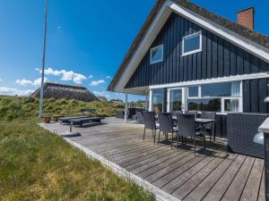 a wooden deck with chairs and a table on a house at Holiday home Fanø CCVIII in Fanø