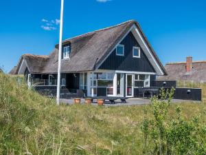 a house with a black roof on the beach at Holiday home Fanø CCVIII in Fanø