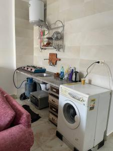 uma cozinha com uma máquina de lavar roupa e uma mesa em شاليه بقرية كورونادو مارينا - Coronado Marina عائلات فقط em Ain Sokhna