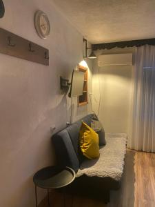 a room with a couch with a yellow pillow at ZANI Hostel in Prizren