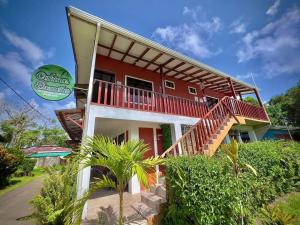 a red and white house with a balcony at Cabinas ensueños in Tortuguero