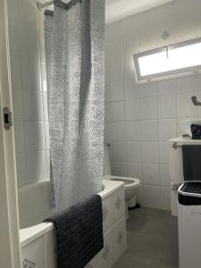 a bathroom with a shower curtain and a toilet at Villa BB in Sanxenxo +18 photos