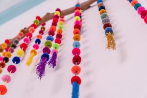 a row of colorful tassels on a wall at Casa Ramona in Flores