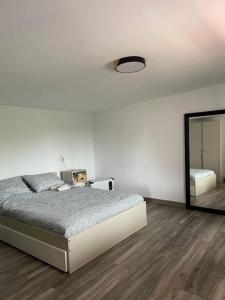 biała sypialnia z łóżkiem i lustrem w obiekcie Villa BB w mieście Sanxenxo