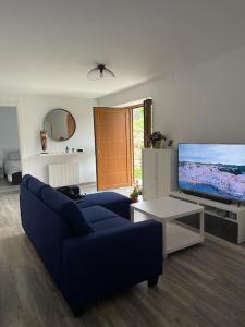 a living room with a blue couch and a tv at Villa BB in Sanxenxo