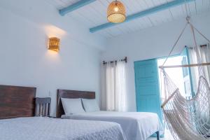 - une chambre avec 2 lits et un hamac dans l'établissement Casa Ramona, à Flores