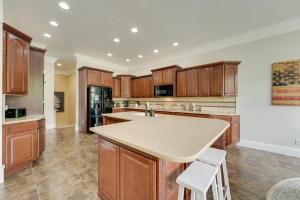 a kitchen with wooden cabinets and a large island at 4 Mi to Branson Landing Huge Home with Game Room! in Branson