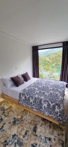 a bedroom with a bed with a large window at Koman Paradise by Romina in Shkodër