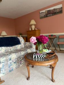 a living room with a table with a vase of flowers on it at Panoramic Ocean View in Nanaimo