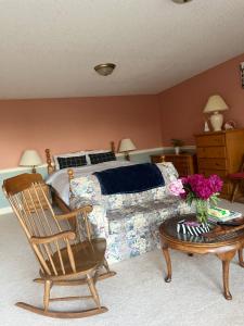 a bedroom with a bed and a chair and a table at Panoramic Ocean View in Nanaimo