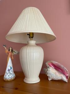 a white lamp sitting on top of a table with a doll at Panoramic Ocean View in Nanaimo