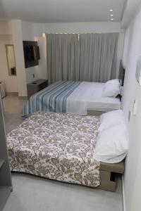 two beds in a hotel room with at Arpoar Suítes 330 in João Pessoa
