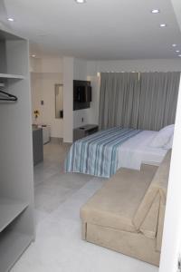 a hotel room with a bed and a couch at Arpoar Suítes 330 in João Pessoa