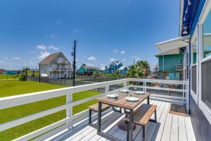 una terraza con una mesa de madera en una casa en Bright Jamaica Beach Getaway Less Than 1 Mi to Shore!, en Galveston