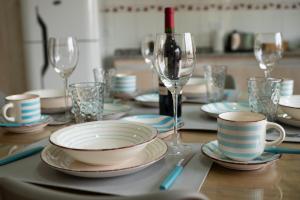 una mesa con platos y tazas y copas de vino en Maipu Luxury Apartment en Maipú