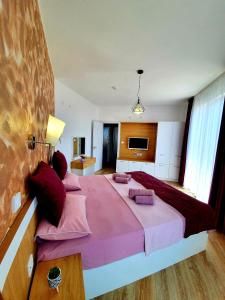 sypialnia z dużym łóżkiem z różową pościelą i poduszkami w obiekcie Old Sailor Apartment w Obzorze