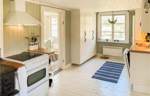 Il comprend une cuisine avec des appareils électroménagers blancs et du parquet. dans l'établissement Nice Home In Valdemarsvik With Kitchen, à Valdemarsvik