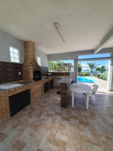 uma grande cozinha com uma mesa e uma lareira em Casarão de frente para a lagoa de Praia Seca em Praia Seca