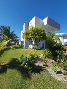 una casa blanca con un patio con plantas en Casarão de frente para a lagoa de Praia Seca en Praia Sêca