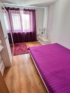 een slaapkamer met een groot paars bed in een kamer bij príjemné ubytovanie in Košice