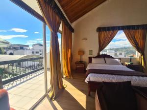 基多的住宿－Suites & Hotel Gonzalez Suarez，一间卧室设有一张床和一个美景阳台
